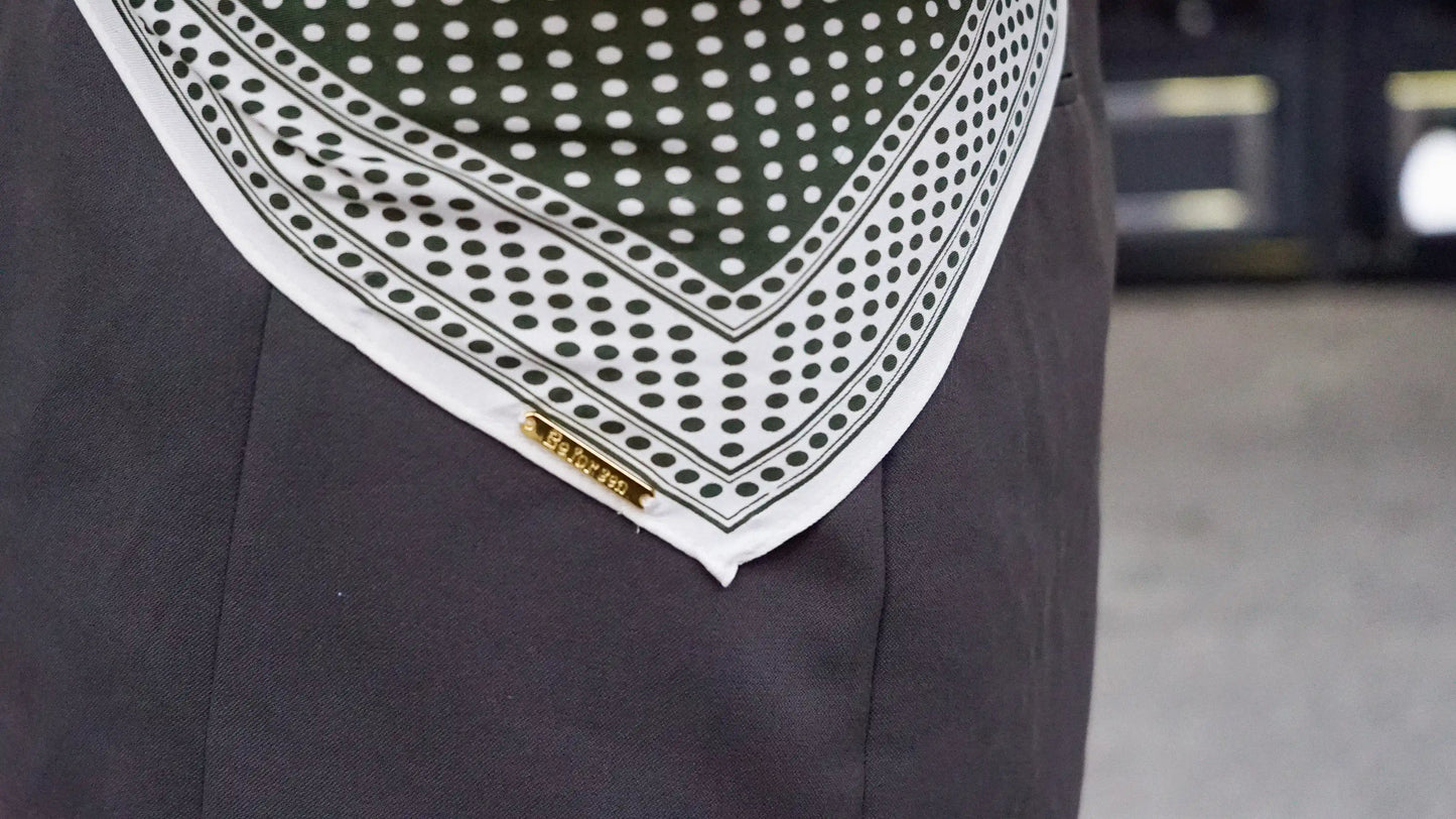 Pañuelo verde en forma triangular con diseño clásico.